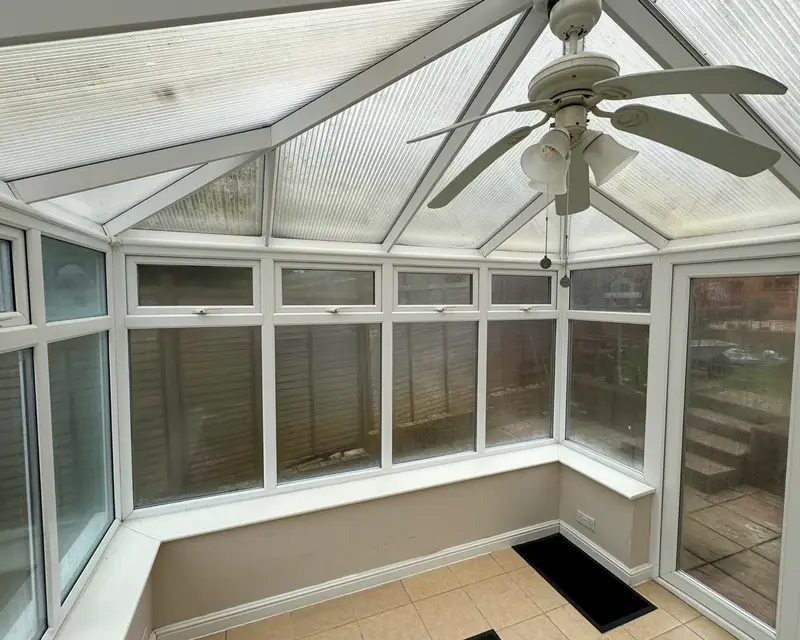 Ceiling fan hanging under a polycarbonate conservatory roof