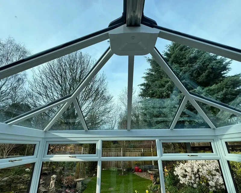 Inside a glass roof conservatory looking up at the sky