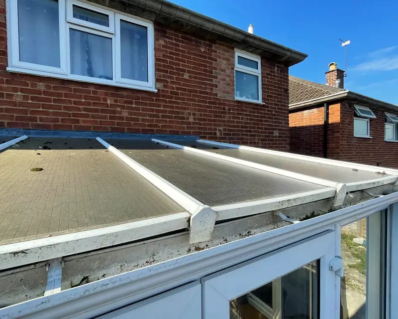 Grimy polycarbonate lean-to roof seen close up from outside