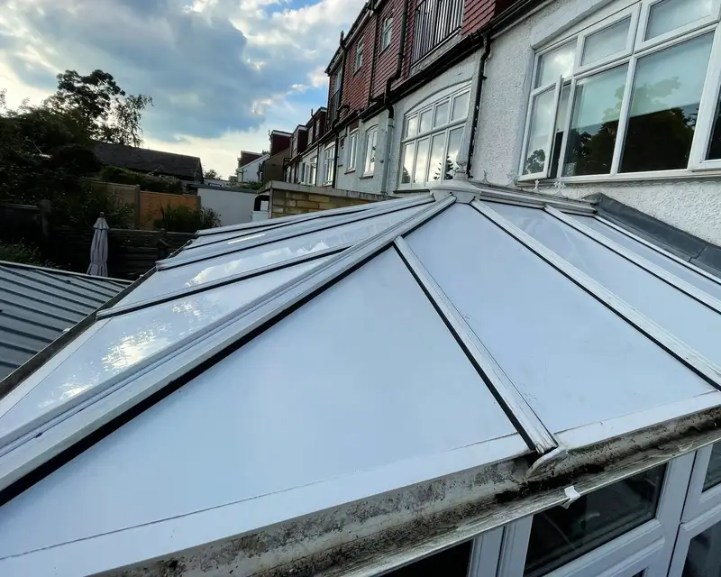 Glass conservatory roof on a terrace with a dirty gutter