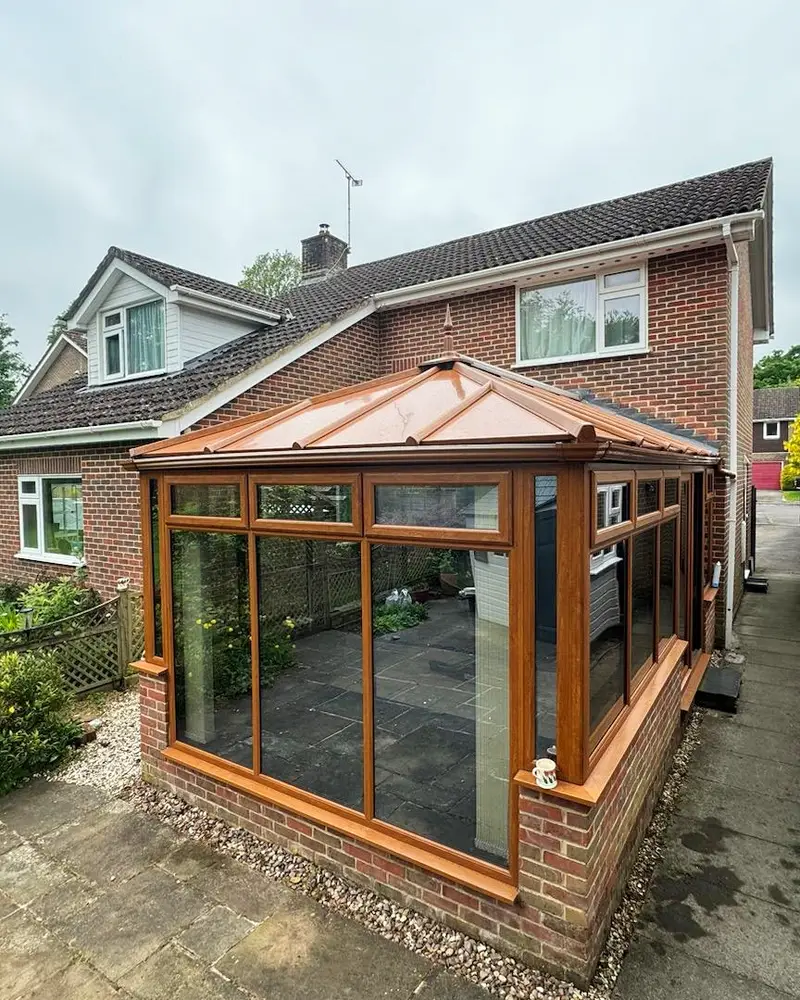 Oak effect conservatory with a copper coloured panel roof