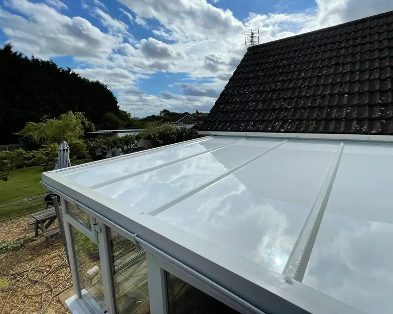 White panel lean-to roof under a stormy sky