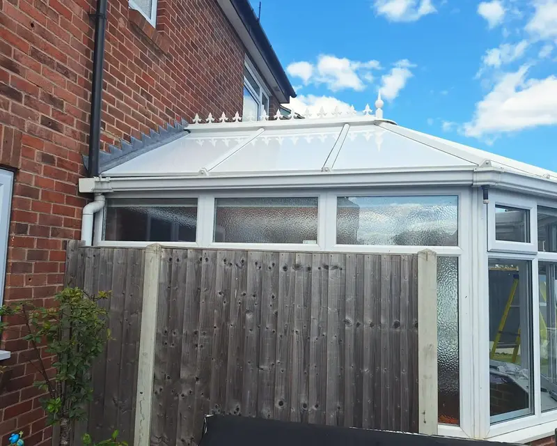 Victorian conservatory with a white panel roof in sunshine