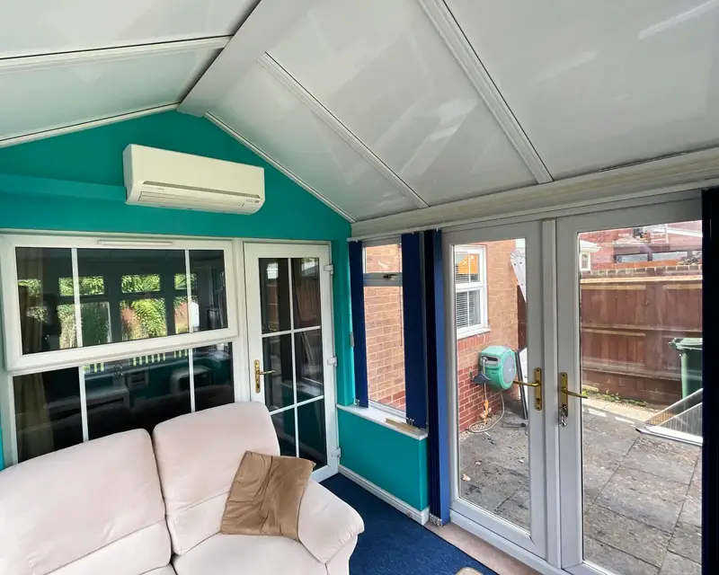 Conservatory lounge with sofa under a panel roof