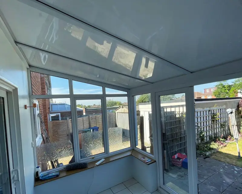 Lean-to conservatory with white panel ceiling and pale floor