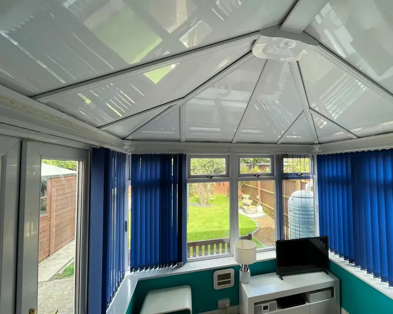 Teal walled conservatory with a white panel ceiling