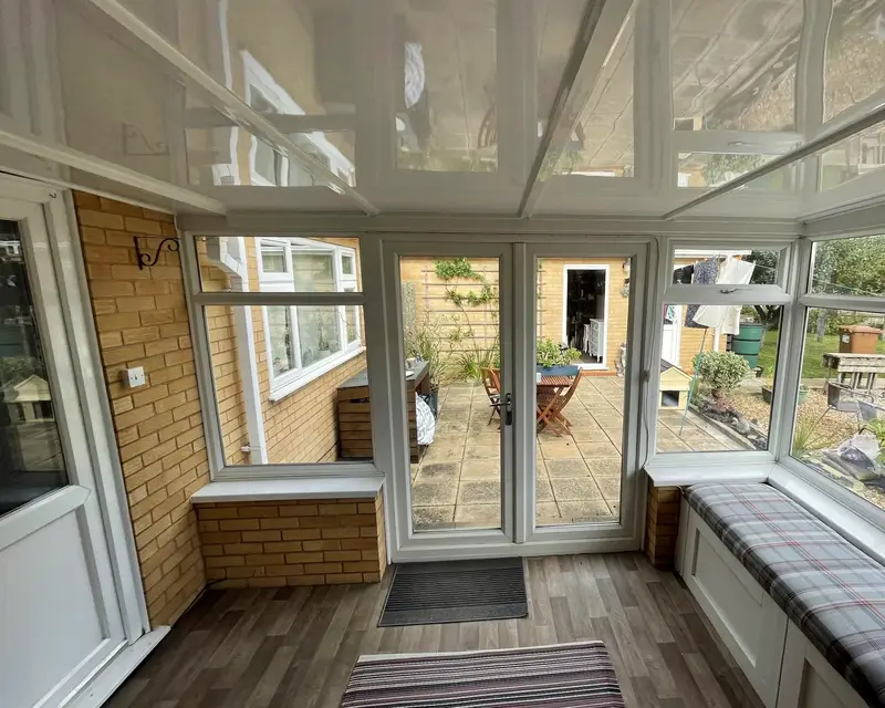 Window seat in a conservatory with a glossy panel ceiling